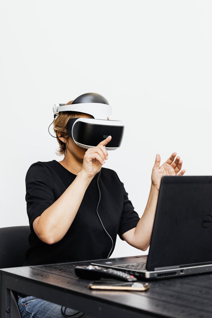 A woman using a VR headset interacts with a laptop, symbolizing futuristic technology.